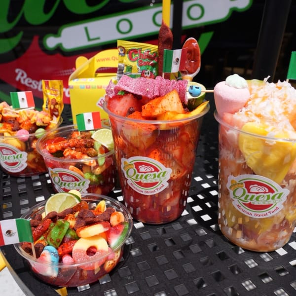 Assortment of Quesa Loco Mexican street food cups filled with fruit, candy, and chili.