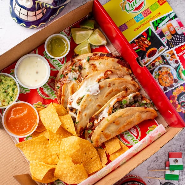 Quesa Loco's cheesy birria tacos, tortilla chips, guacamole, and salsas in a takeout box.