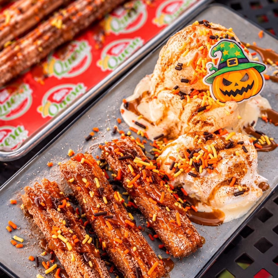 Halloween-themed dessert platter with churros, soft-serve ice cream, orange and chocolate sprinkles, and a pumpkin witch decoration.