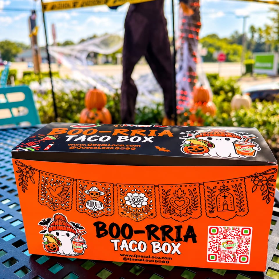 Bright orange Boo-RRia Taco Box with Halloween-themed illustrations displayed on an outdoor table.